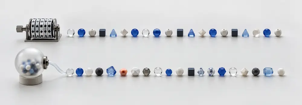 A repeating mechanical wheel and an entropy chamber produce two visually varied rows of small tokens.