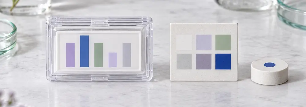 A sealed measurement specimen sits apart from its reference tile and decision marker.
